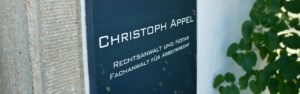 Blaues Schild mit Schriftzug Christoph Appel Rechtsanwalt und Notar Fachanwalt für Arbeitsrecht.
